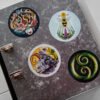 Folder with four stickers of the illustrations “The Stag’s Head”, “Sacro Nectare”, “Double Koru” and “Mountain Goat Elder”