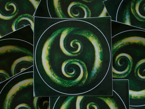 Round Double Koru Sticker lying on other green koru stickers with colour inspired by the precious New Zealand greenstone