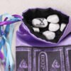 Purple poly-satin Bastet Cat pouch with black poly-satin lining, white rune stones that spell Imogen are sitting in the pouch