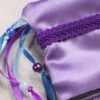 Close Up of Bastet Pouch showing purple, dark and light blue ribbons, iridescent blue and pearl purple plastic beads brocade