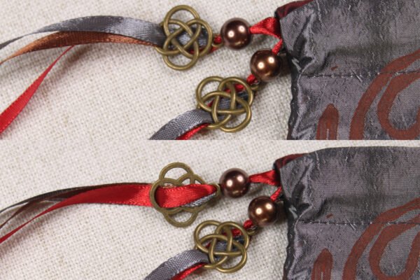 Close Up of Cernunnos Stag God Pouch showing red, grey and brown ribbons, pearl brown plastic beads and metal knotwork charms