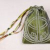 Closed moss green handprinted fabric drawstring bag with Chalice Well Hawthorne flower print, ribbons and beads spread out