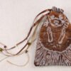 Closed brown handprinted fabric drawstring bag with Hedgehog and grape print with ribbons and beads splayed out