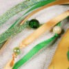 Close Up of Selkie Pouch green and gold ribbons, iridescent green and cream plastic beads and clear green plastic beads