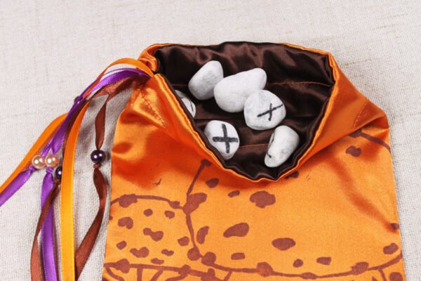 Orange Poly-Satin toadstool pouch with brown poly-satin lining, white rune stones that spell Imogen are sitting in the pouch