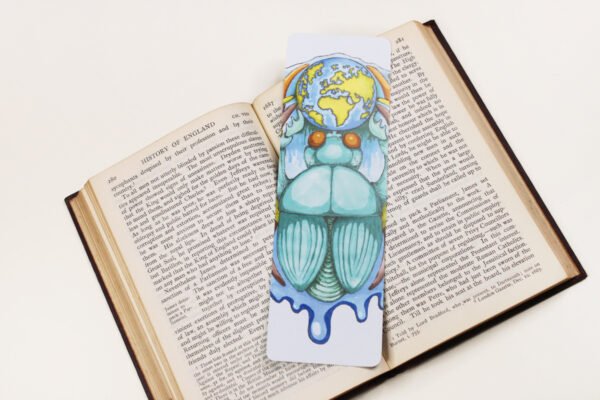 Scarab Beetle, or Khepri, bookmark with teal, turquoise and bright green colours on a black and white text page of open book