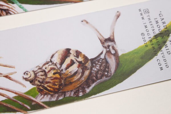 Detail of Garden Snail Bookmark showing a garden snail with brown and beige shell sitting on a thick blade of grass