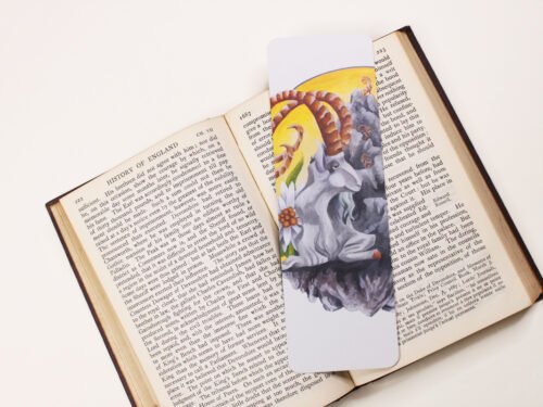 Steinbock or Alpine Ibex, Capra ibex, bookmark with yellow, grey and green colours on black and white text page of open book