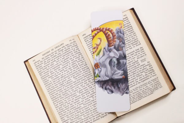 Steinbock or Alpine Ibex, Capra ibex, bookmark with yellow, grey and green colours on black and white text page of open book