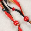 Close Up of European Oak Deer God Pouch showing red, black and gold ribbons and red wooden beads and red silver plastic beads