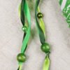 Close Up of Chalice Well Lid Pouch showing different shades of green ribbons, green plastic beads and green wooden beads