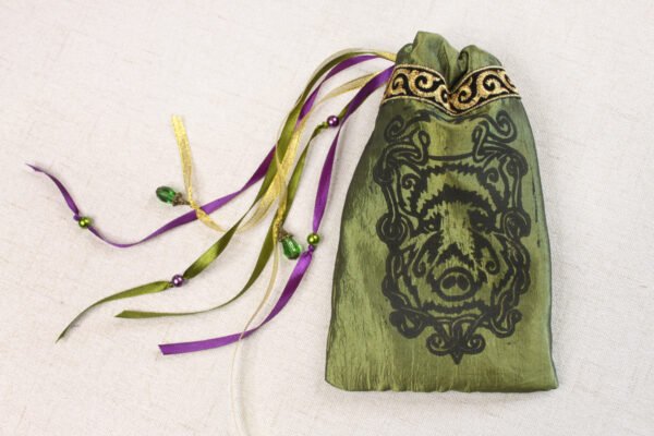 Moss Green handprinted fabric drawstring bag with boar knotwork print closed with colourful ribbons and beads splayed out