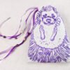 Closed cream coloured handprinted fabric drawstring bag with Hedgehog and grape print with ribbons and beads splayed out