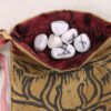Gold taffeta stag Cernunnos pouch with burgundy taffeta lining, white rune stones that spell Imogen are sitting in the pouch