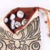 Beige Taffeta Cernunnos pouch with burnt sienna lining, white rune stones that spell Imogen are sitting in the pouch