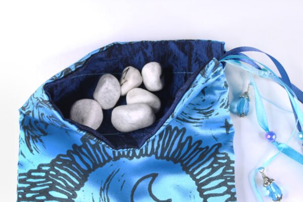 Blue Poly-Satin Moon Gate pouch with dark blue taffeta lining, white rune stones that spell Imogen are sitting in the pouch