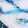 Close Up of Moon Pouch showing turquoise and dark blue ribbons, pearly blue plastic beads and metal and glass bead charms