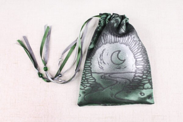 Green handprinted fabric drawstring bag with Moon Gate and Stars print closed with colourful ribbons and beads splayed out