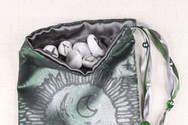 Green Poly-Satin Moon Gate pouch with dark grey poly-satin lining, white rune stones that spell Imogen are inside the pouch